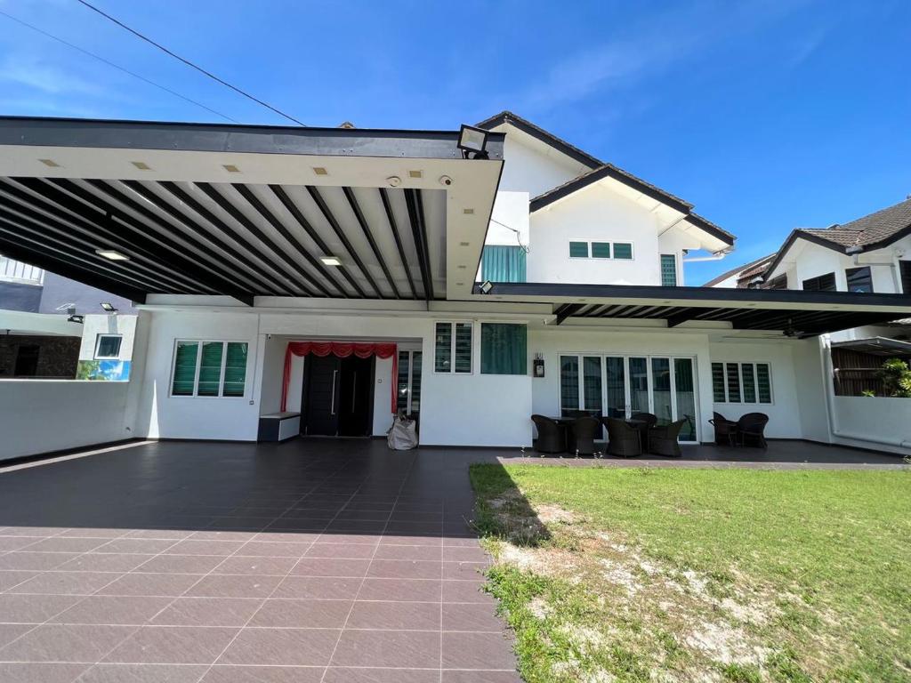 uma grande casa branca com um grande pátio em HomeAway Paradise @ Klebang Malacca em Malaca