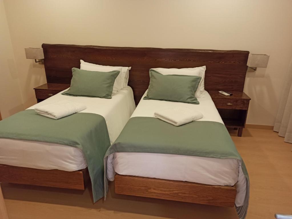 two beds sitting next to each other in a room at Fontanário House in Alpiarça