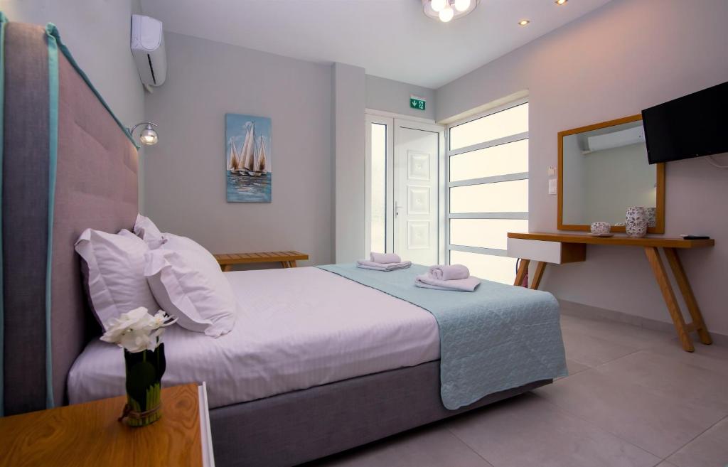 a bedroom with a large bed and a television at Olea Garden Apartments in Stavros