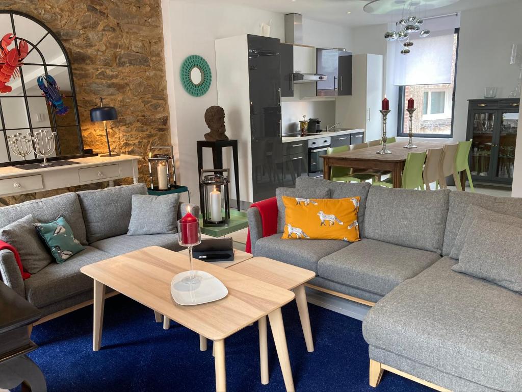 a living room with two couches and a table at GITE Maison Nomah Maison haut standing proche plages, classé 5* in Plouha