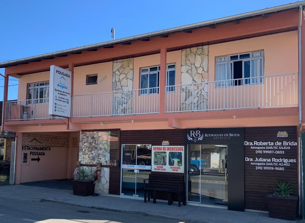 a building with a bench in front of it at Pousada Angela in Urubici