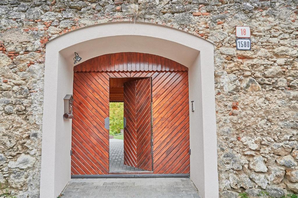 eine Holztür in einer Steinmauer mit einer Tür in der Unterkunft "Na Skale " Apartment in center, free parking in Bojnice
