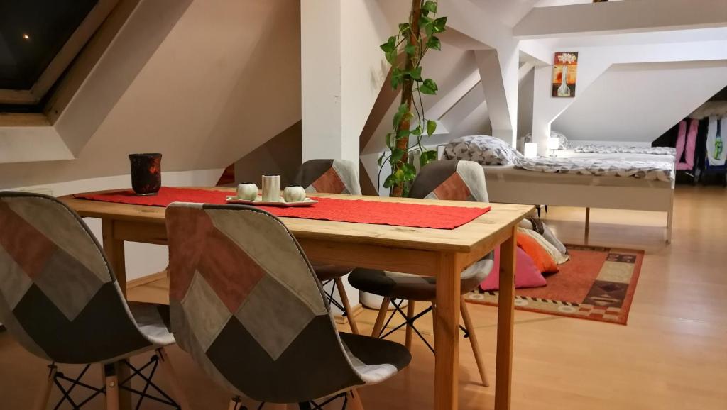ein Esszimmer mit einem Holztisch und Stühlen in der Unterkunft Attic Oelsnitz am Hegebach mit Netflix und Parkplatz Self Check-in in Oelsnitz
