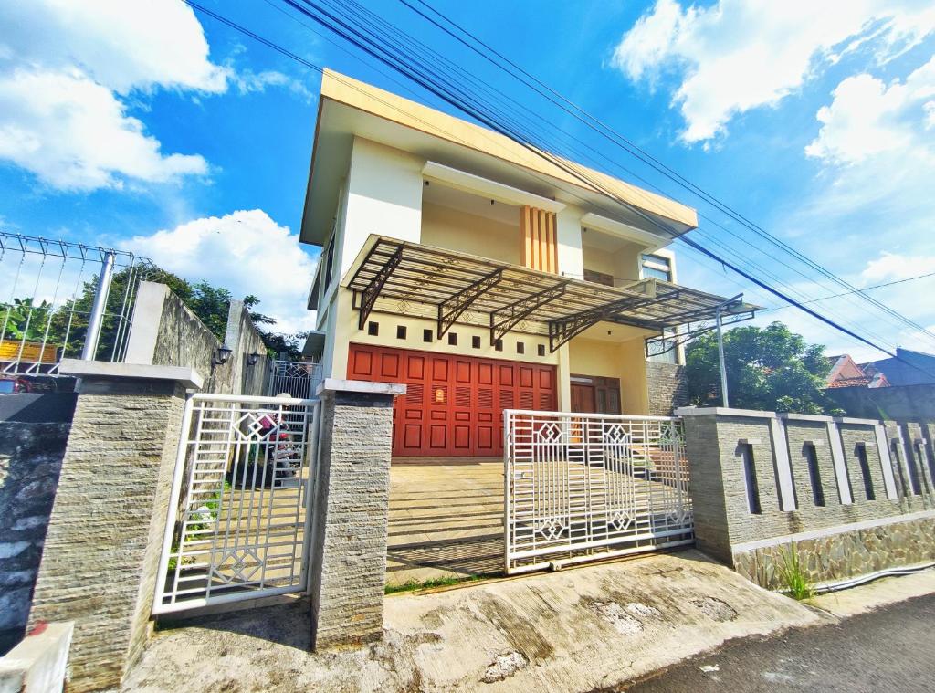 スマランにあるHomestay Parikesit Rent Full Houseの赤い扉と門のある家