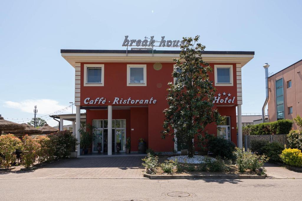 un bâtiment rouge avec un panneau indiquant le tableau de bord du café dans l'établissement Hotel Break House Ristorante, à Terranuova Bracciolini