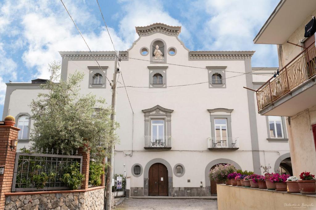 un edificio blanco con una torre de reloj en la parte superior en Villa Vesuviana, en Torre del Greco