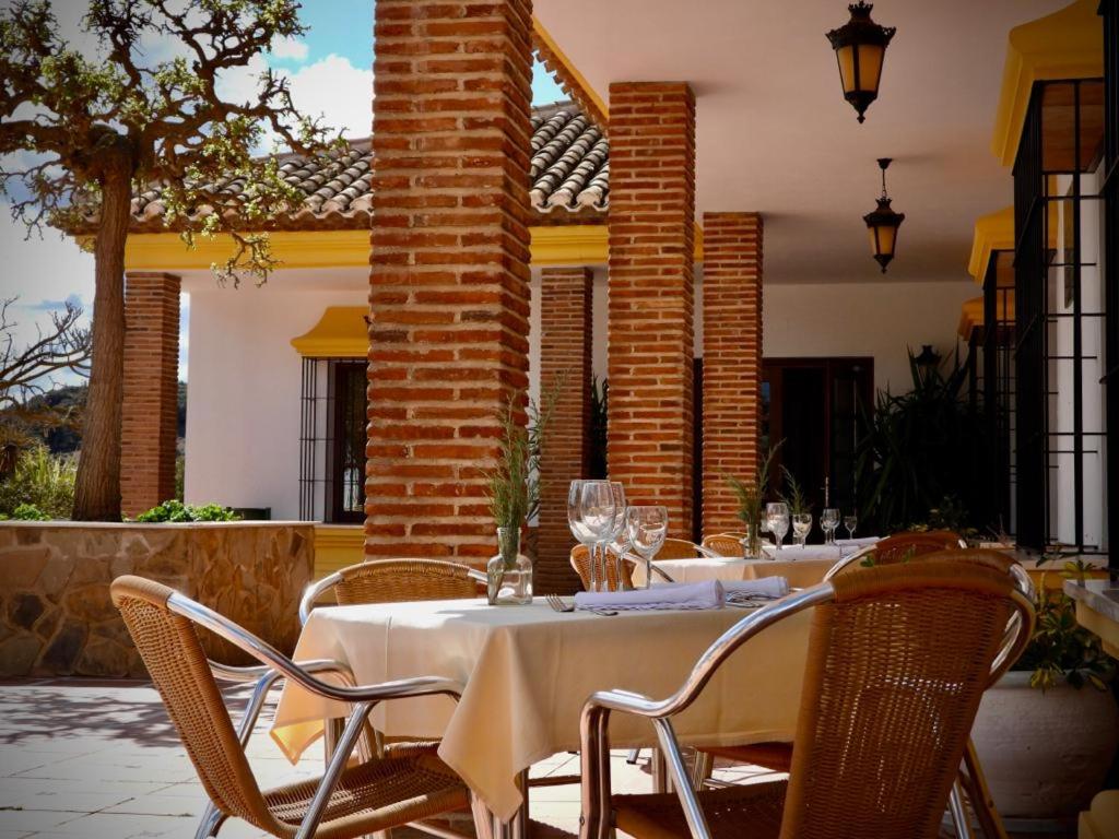 uma mesa com uma toalha de mesa branca num pátio em Hotel Rural Carlos Astorga em Archidona