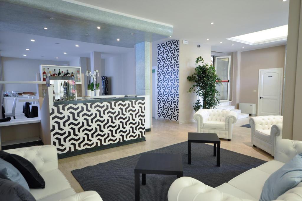 a living room with white furniture and a salon at Hotel Airone in Marina di Pietrasanta