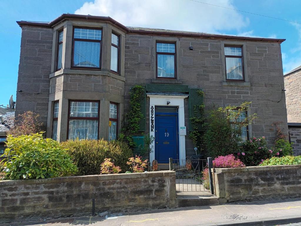 uma casa de tijolos castanhos com uma porta azul em Athollbank Guest House em Dundee