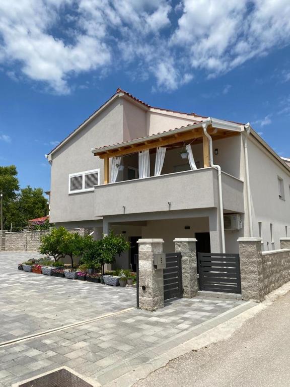 a large white house with a driveway at L&L in Pakoštane