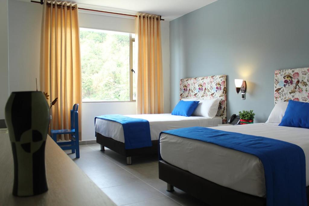 Habitación de hotel con 2 camas y ventana en Hotel Ventura en Bucaramanga