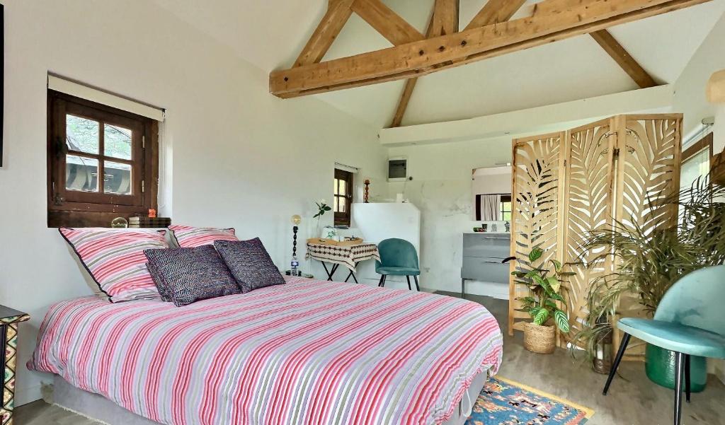 een slaapkamer met een groot bed en een keuken bij Le petit Aventin in Brosville