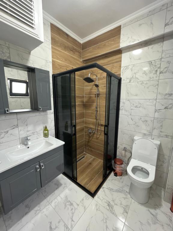 ein Bad mit einer Dusche, einem WC und einem Waschbecken in der Unterkunft Sapanca Çeşme Villaları in Feyziye
