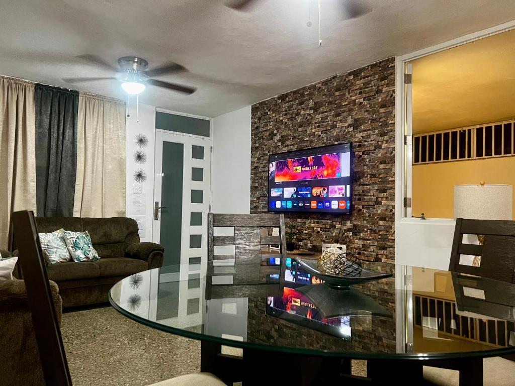 een woonkamer met een glazen tafel en een televisie bij “Lucor D-Eight House” New Entire Home in the Town… in Rincon