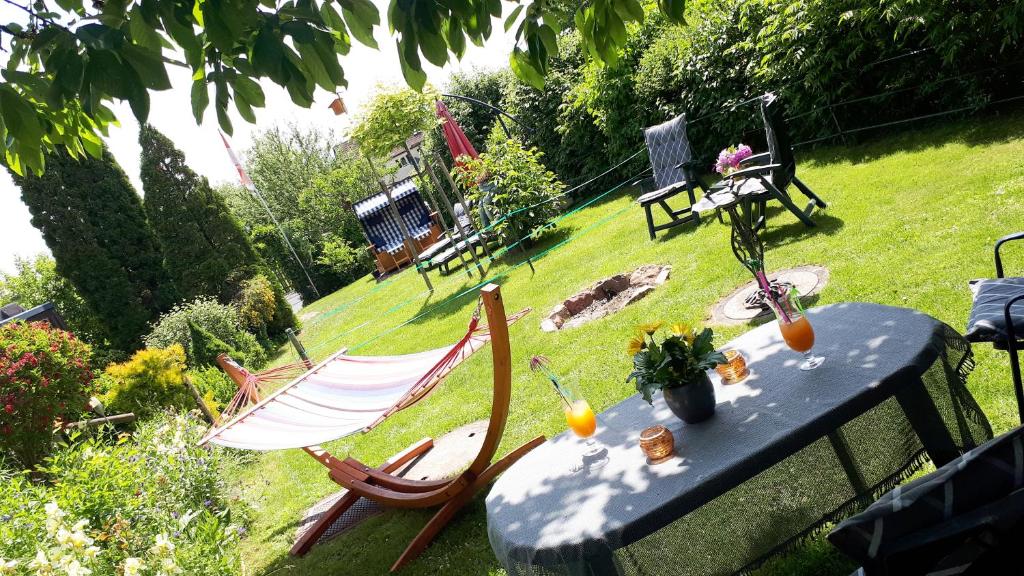 una mesa y sillas en un jardín con mesa y sillas en Privatzimmer mit Gemeinschaftsbad - Zur Fliegerbank in der Rhön, en Burkardroth