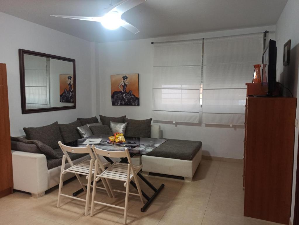 uma sala de estar com um sofá e uma mesa em Apartamento Teatinos Universidad em Málaga