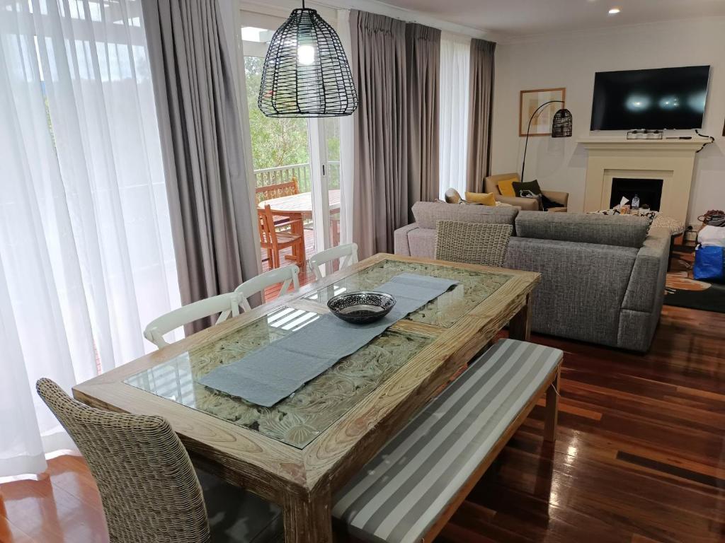 sala de estar con mesa y sofá en Cypress Lakes Villa Domenica, en Pokolbin