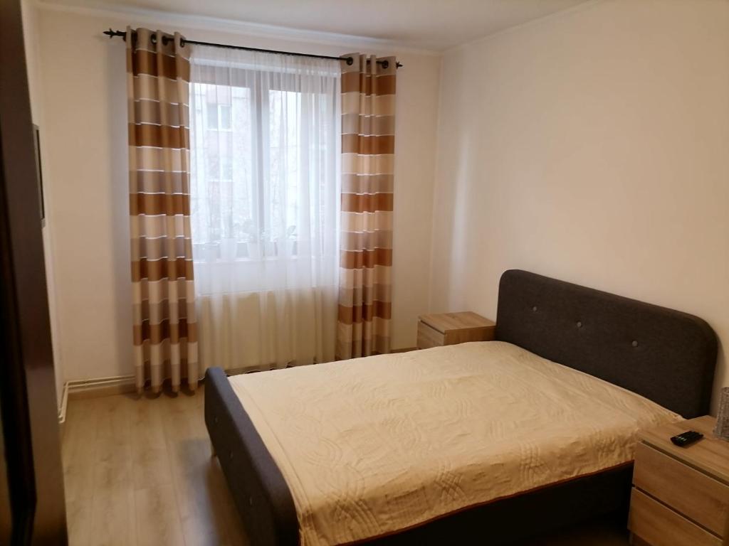 a small bedroom with a bed and a window at Joy Apartman in Sovata