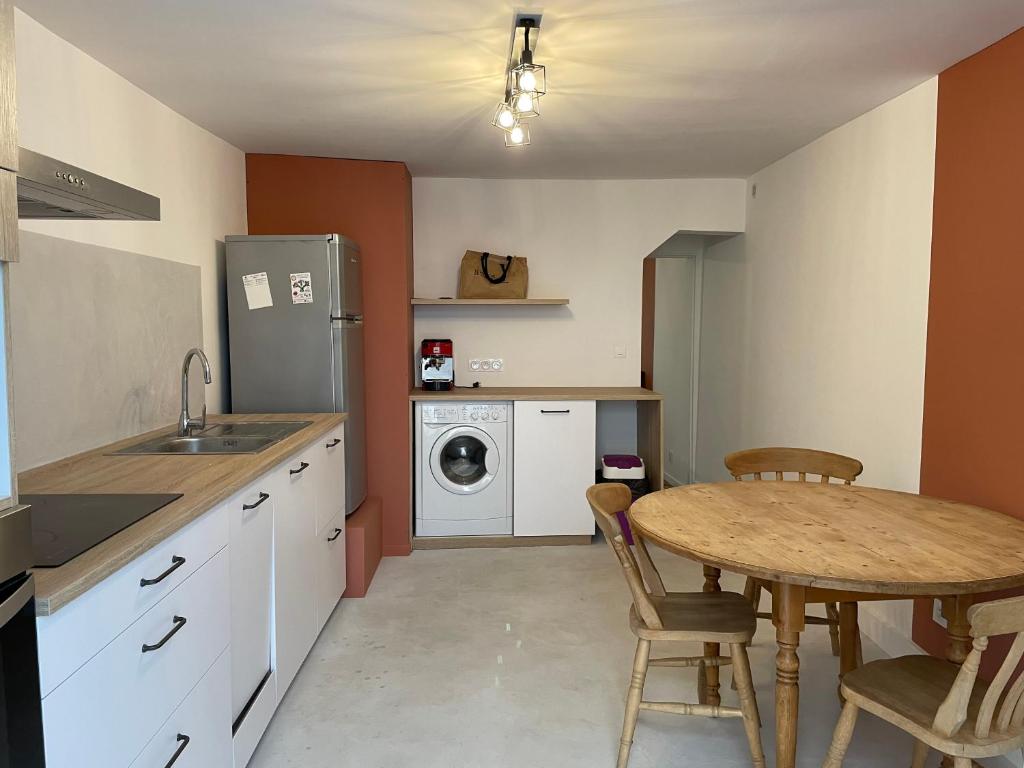 a kitchen with a table and a washing machine at LA MAISON IM in Avignon