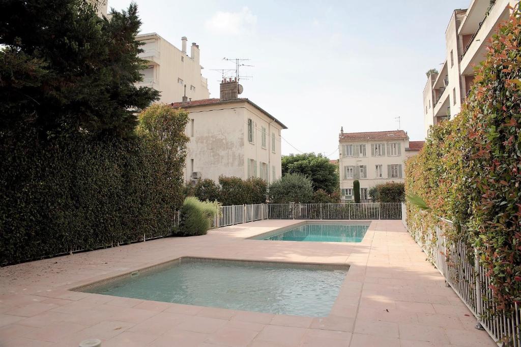 una piscina en medio de un patio en T2 proche de la gare, à 10 minutes à pieds de la Croisette, piscine & parking dans résidence de haut standing, en Cannes