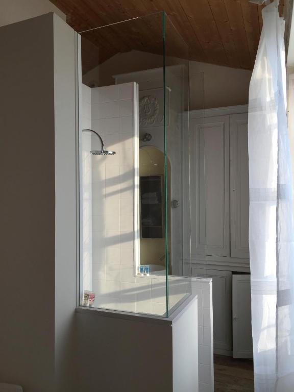 a glass cabinet with a mirror in a room at Hôtel Le Sénéchal in Ars-en-Ré