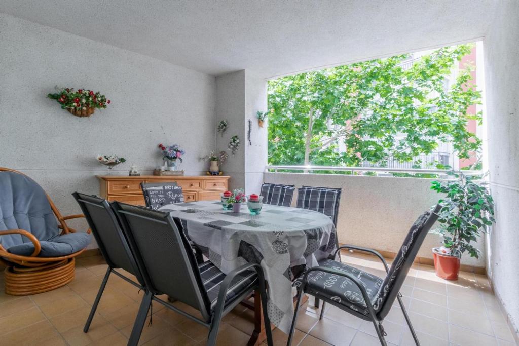 d'une salle à manger avec une table, des chaises et une fenêtre. dans l'établissement Albamar Apartamento 6 personas con parking cerca de la playa, à Calp