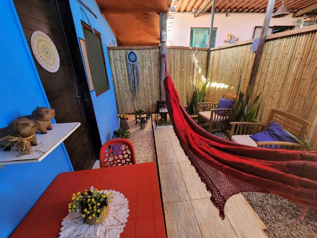 a hammock in a room with a table and chairs at Pousada Magia in Fernando de Noronha