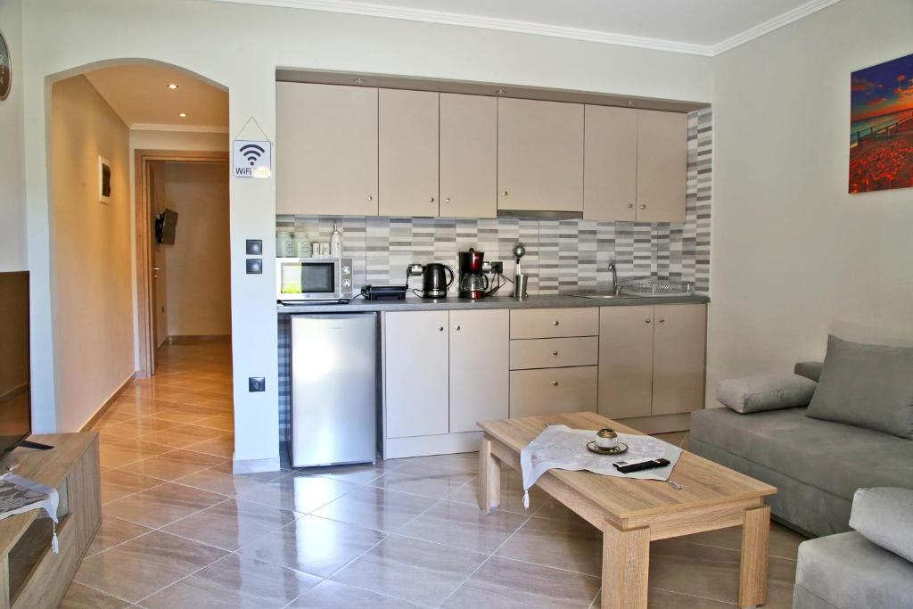 a kitchen and living room with a couch and a table at John's apartment's near Athens Airport!! in Spáta