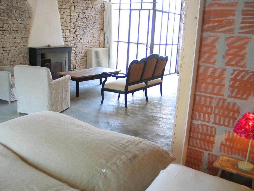 a room with a bed and chairs and a fireplace at Hôtel Le Sénéchal in Ars-en-Ré