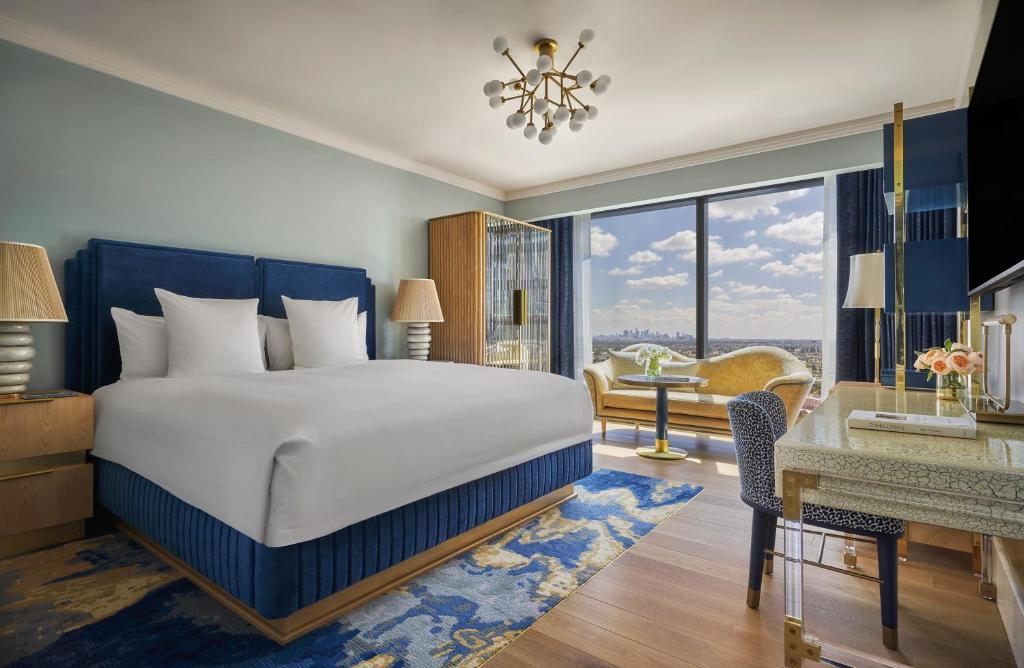 a bedroom with a large bed and a large window at Pendry West Hollywood in Los Angeles