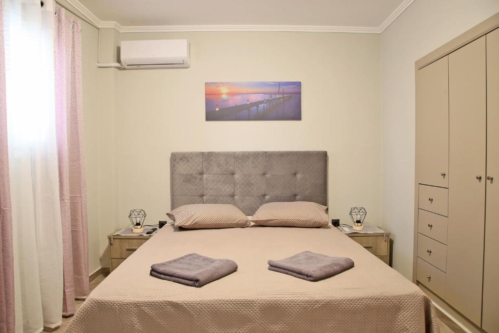 a bedroom with a bed with two pillows on it at Comfortable apartment near Athens Airport!! in Spáta