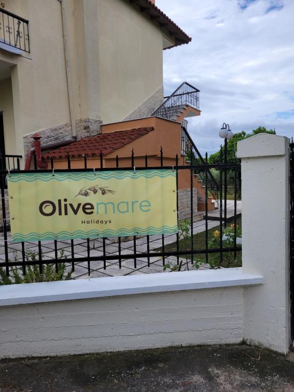 a sign on a fence in front of a building at Olivemare Holidays in Nea Irakleia