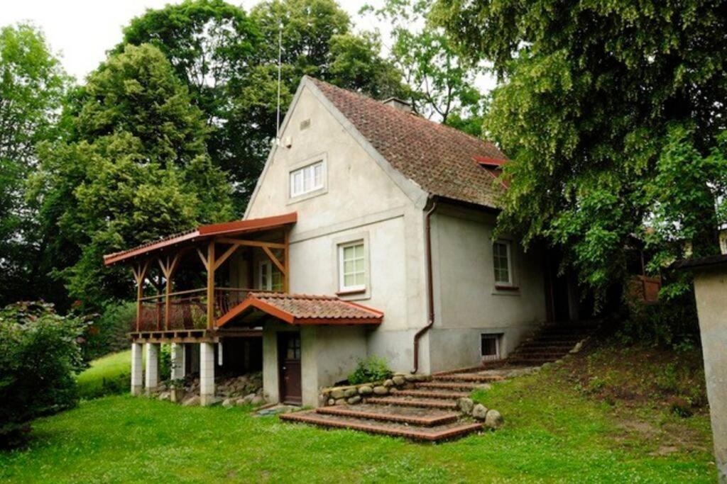 a large white house with stairs in the yard at Całoroczny dom w Powałczynie w spokojnej okolicy. in Powałczyn