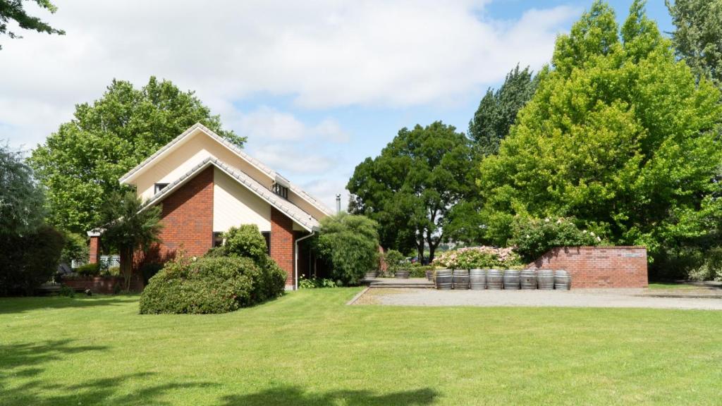 a red brick house with a grass yard at Fairhall Lodge in Blenheim