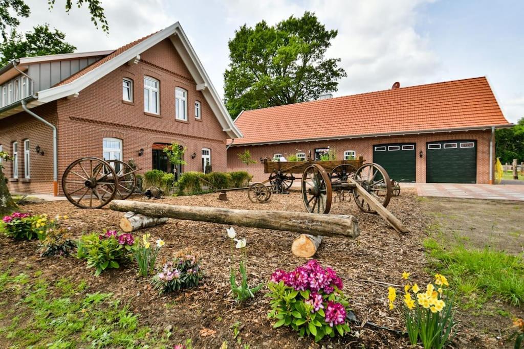 a house with a garden with flowers in front of it at Dat-Landhuus in Molbergen