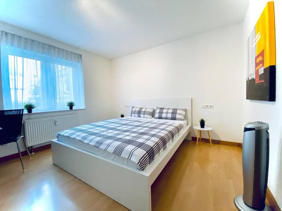 biała sypialnia z łóżkiem i oknem w obiekcie Auszeit Apartment SEEPERLE mit 4 Schlafzimmern, 600 m Luftlinie bis zum Bodenseeufer, in unmittelbarer Nähe des Bodenseeradwegs, schöne Sonnenterrasse, schnelles Internet, für bis zu 5 Personen w mieście Friedrichshafen