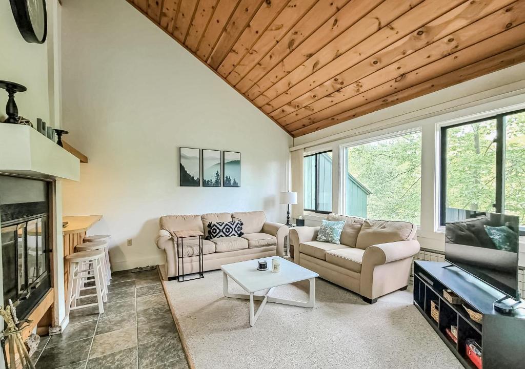 a living room with two couches and a table at Loon Mountain Getaway in Lincoln