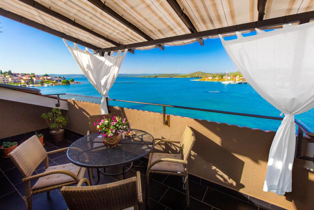 a balcony with a table and chairs and a view of the water at Apartmani Nikolina Seaview in Šibenik