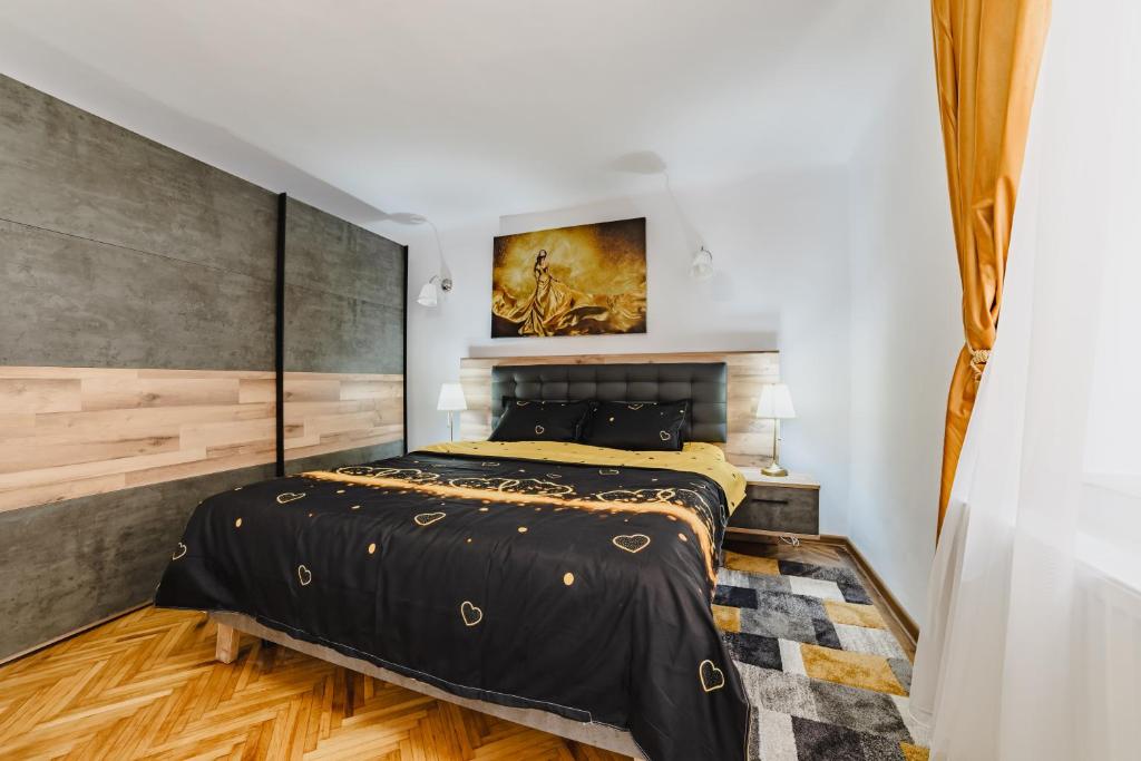 um quarto com uma cama preta com um quadro na parede em Republicii Premium em Braşov