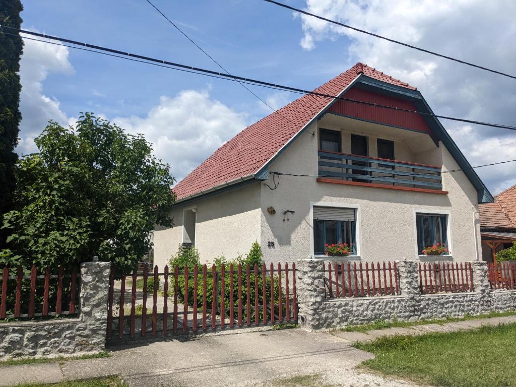 a white house with a fence in front of it at Tulipan Haz in Szilvásvárad