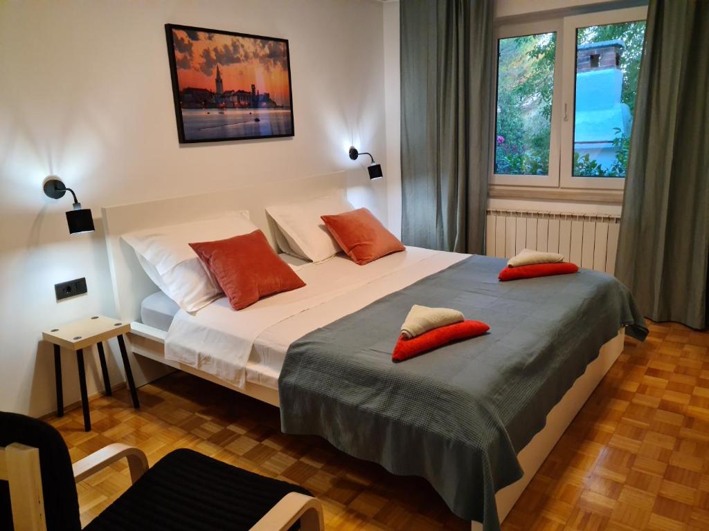 a bedroom with a large bed with red pillows on it at Villa Rosa with yard and children's playground in Vabriga