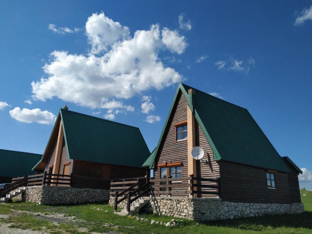 een groot houten huis met een groen dak bij Mountain Soul Rest in Žabljak