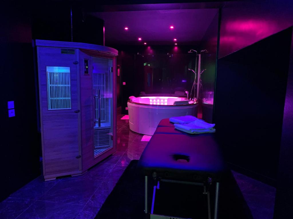 Baño púrpura con bañera y lavabo en La Suite Marylin, Loft de 90m2 avec Sauna et Jacuzzi en Riom