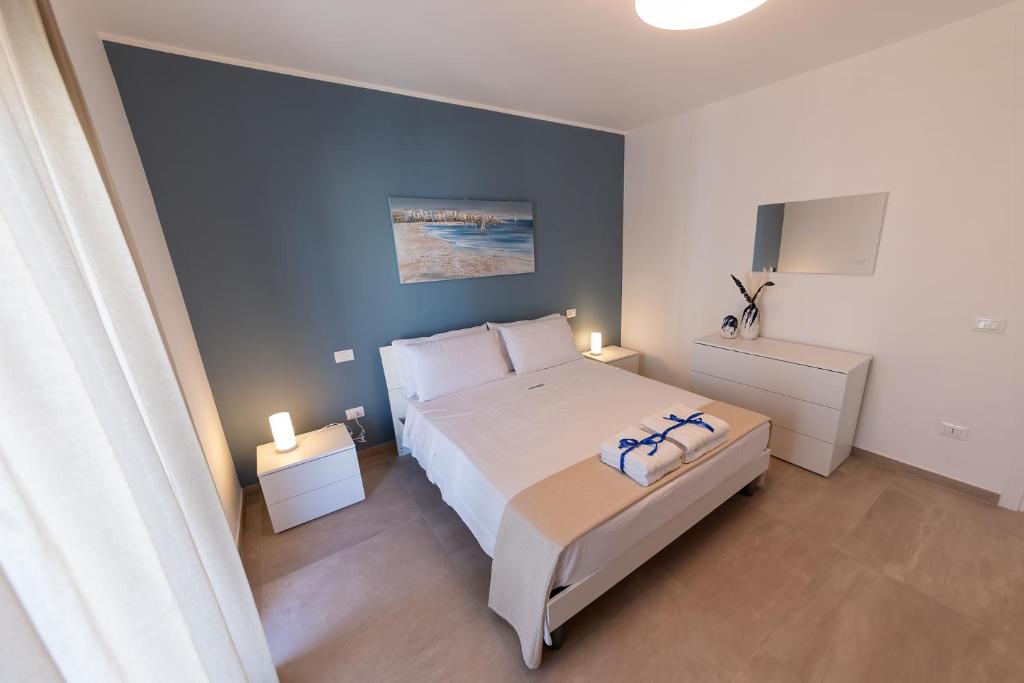 a bedroom with a large bed and two night stands at Alta Marea Sea Apartments in Balestrate