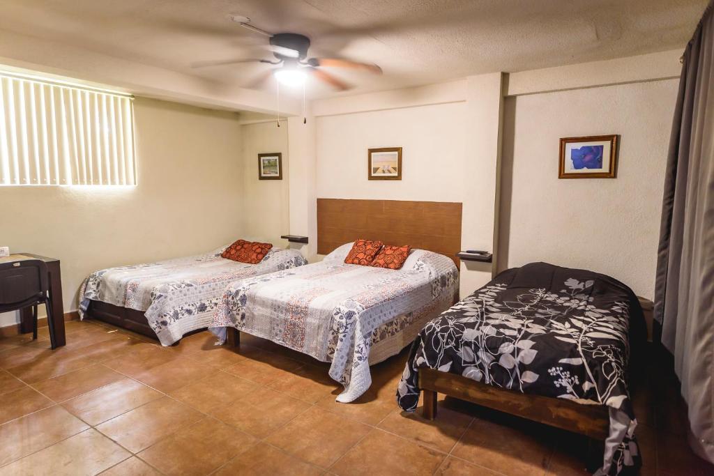 1 dormitorio con 2 camas y ventilador de techo en Suite con 2 recamaras,2mini splits, Parking Wifi 100 mb, cocina, en Ciudad Valles
