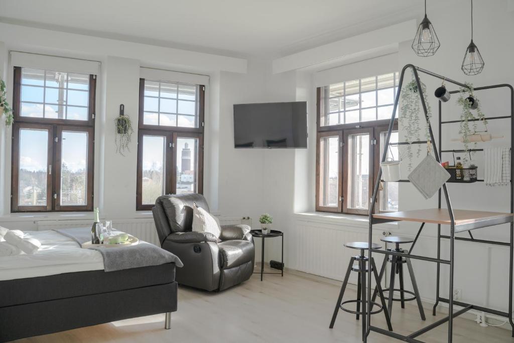 ein Wohnzimmer mit einem Sofa und einem Stuhl in der Unterkunft The Sunset - Top Floor Studio apartment in Pietarsaari