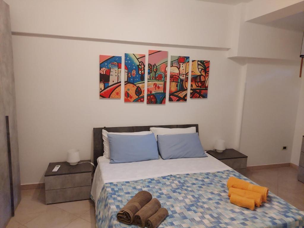 sypialnia z łóżkiem z dwoma obrazami na ścianie w obiekcie Villa Costanza Casa Vacanze w mieście Avola