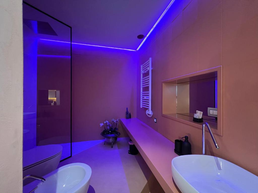 a purple bathroom with a sink and a toilet at Sinestesia in Polignano a Mare