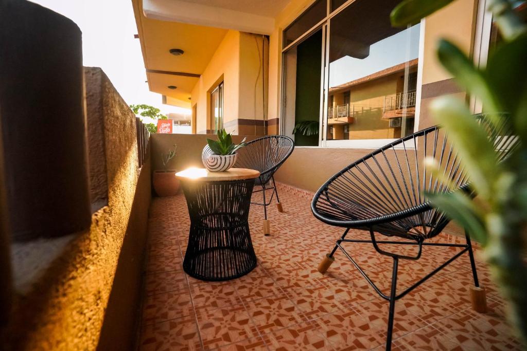 a balcony with two chairs and a table with a plant at Hotel Casa Arena in Zihuatanejo