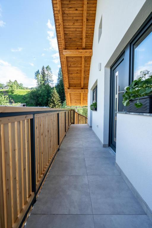 a walkway leading to a balcony with a wooden ceiling at Na-Ture Apartments in Zgornje Gorje